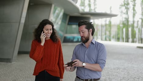 Happy-couple-using-smartphones-outdoor